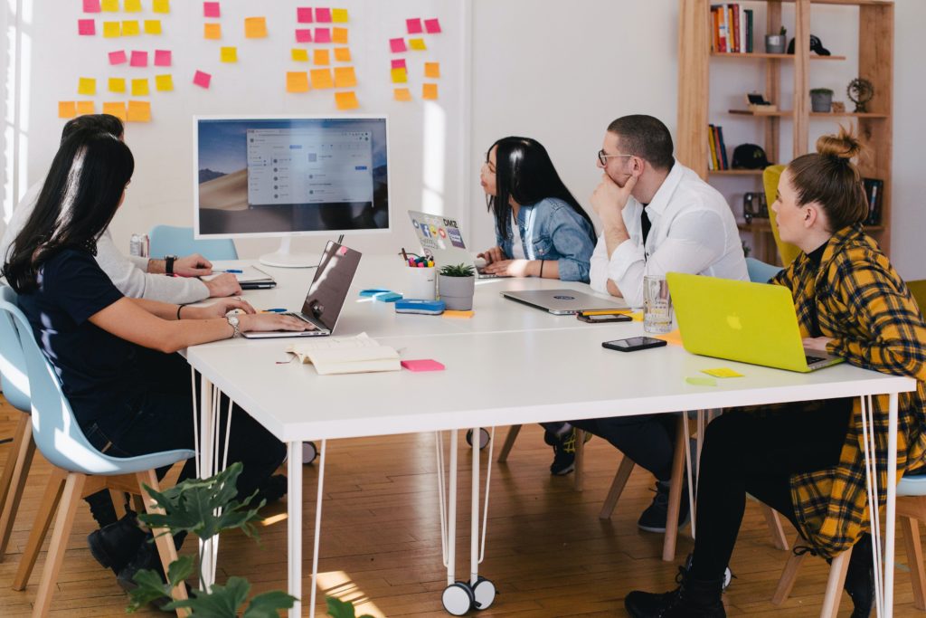 Photo of a team seated around a conference table collaborating on a project by You X Ventures on Unsplash.