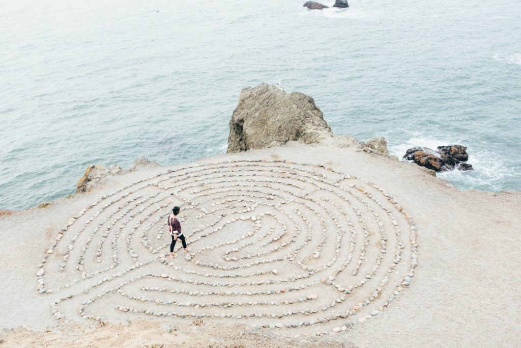 Person walking through a maze made of small stones so that it's easy to navigate.