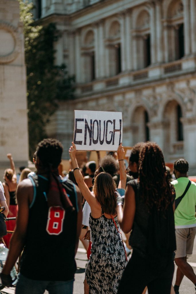 Peaceful protestors holding a sign that says "enough".