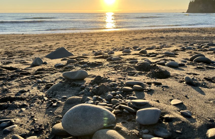 The beach at Port Townsend, WA, at sunset. It's a sandy beach covered in rounded stones.